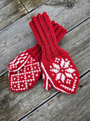 Strikkeoppskrift på selbuvotter til barn med tommel. Bildet viser røde selbuvotter, fine som julegavestrikk, på en rustikk trebakgrunn.